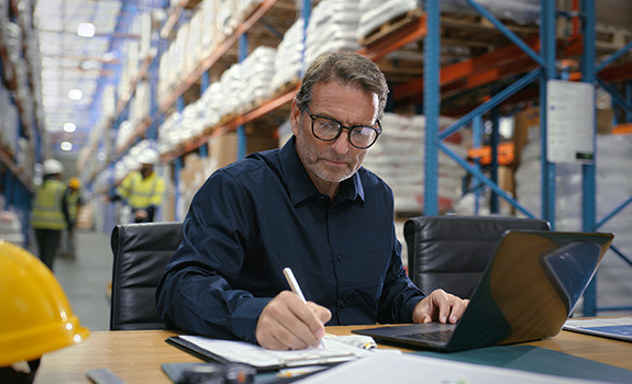 Laptop, writing and logistics with man in warehouse