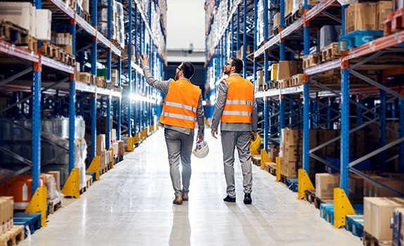 Two businessmen walking around distribution warehouse